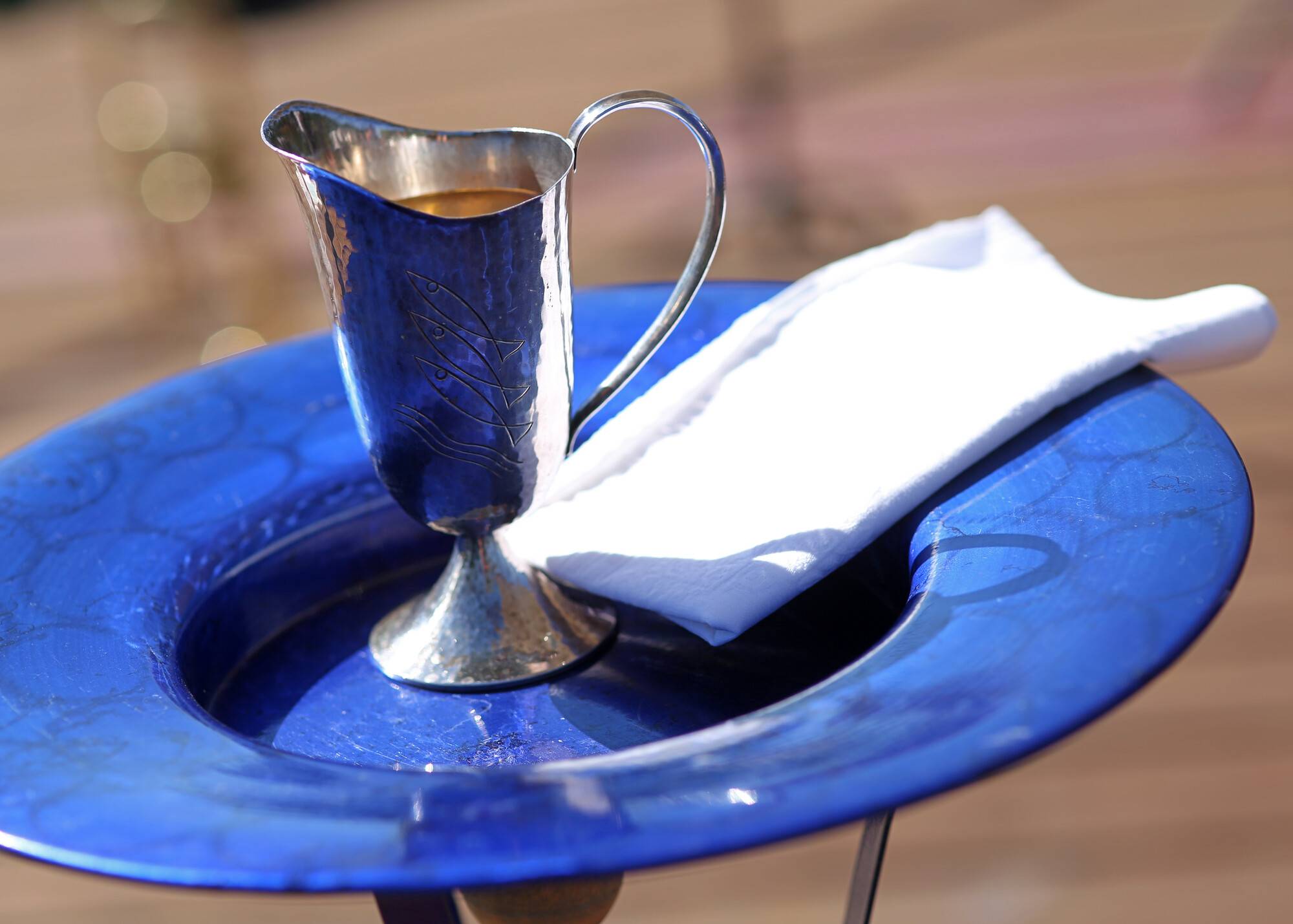 blaue Taufschale mit silberner Kanne und weißem Tuch